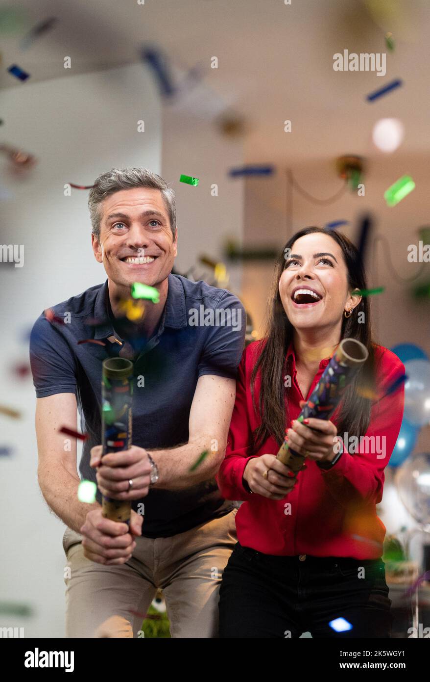 Hamburg, Germany. 10th Oct, 2022. Aline Abboud and Ingo Zamperoni, TV presenters and journalists, spray confetti with confetti cannons on a TV set during the filming of 50 Years of Sesame Street. (recrop) On January 8, 2023, the German Sesame Street celebrates its 50th anniversary. Credit: Daniel Reinhardt/dpa/Alamy Live News Stock Photo