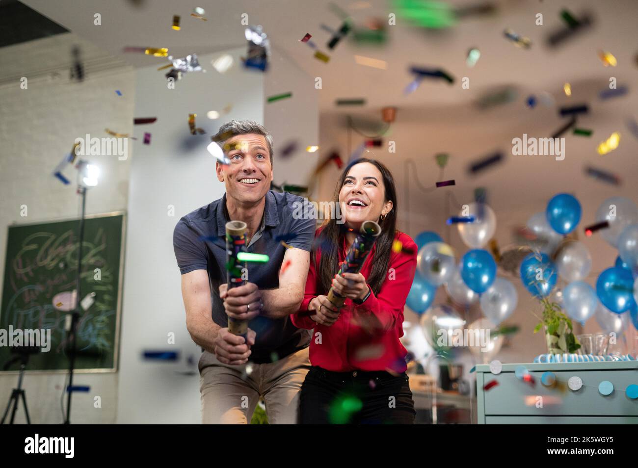 Hamburg, Germany. 10th Oct, 2022. Aline Abboud and Ingo Zamperoni, TV presenters and journalists, spray confetti with confetti cannons on a TV set during the filming of 50 Years of Sesame Street. On January 8, 2023, the German Sesame Street celebrates its 50th anniversary. Credit: Daniel Reinhardt/dpa/Alamy Live News Stock Photo