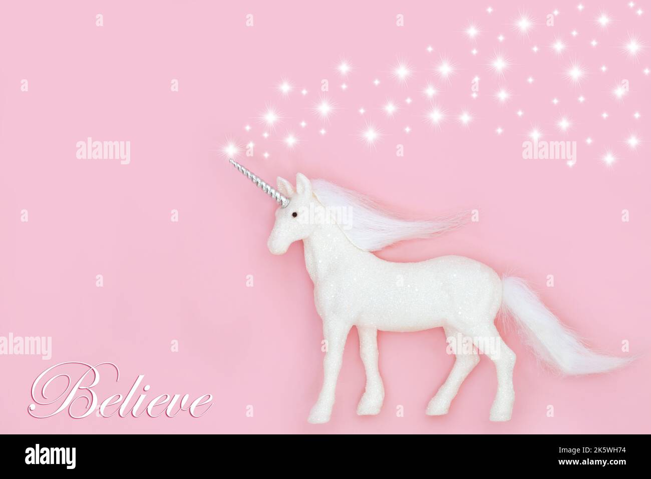 Christmas mythical magical unicorn with believe in magic theme on pink background with white stars. Fairy tale abstract for Xmas and New Year holiday Stock Photo