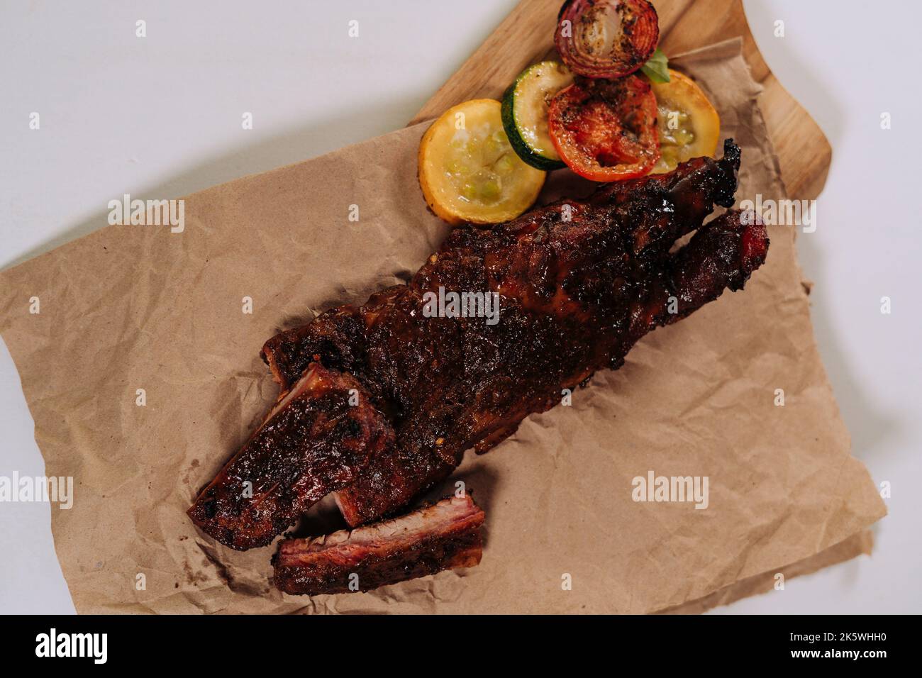 A top view of cooked ribs on a butcher paper on a white background ...