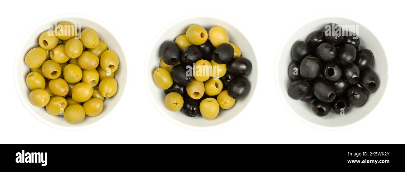 Pitted green and black olives, Hojiblanca, in white bowls, from above. European olives, Olea europaea, a cultivar from Lucena, Spain. Stock Photo
