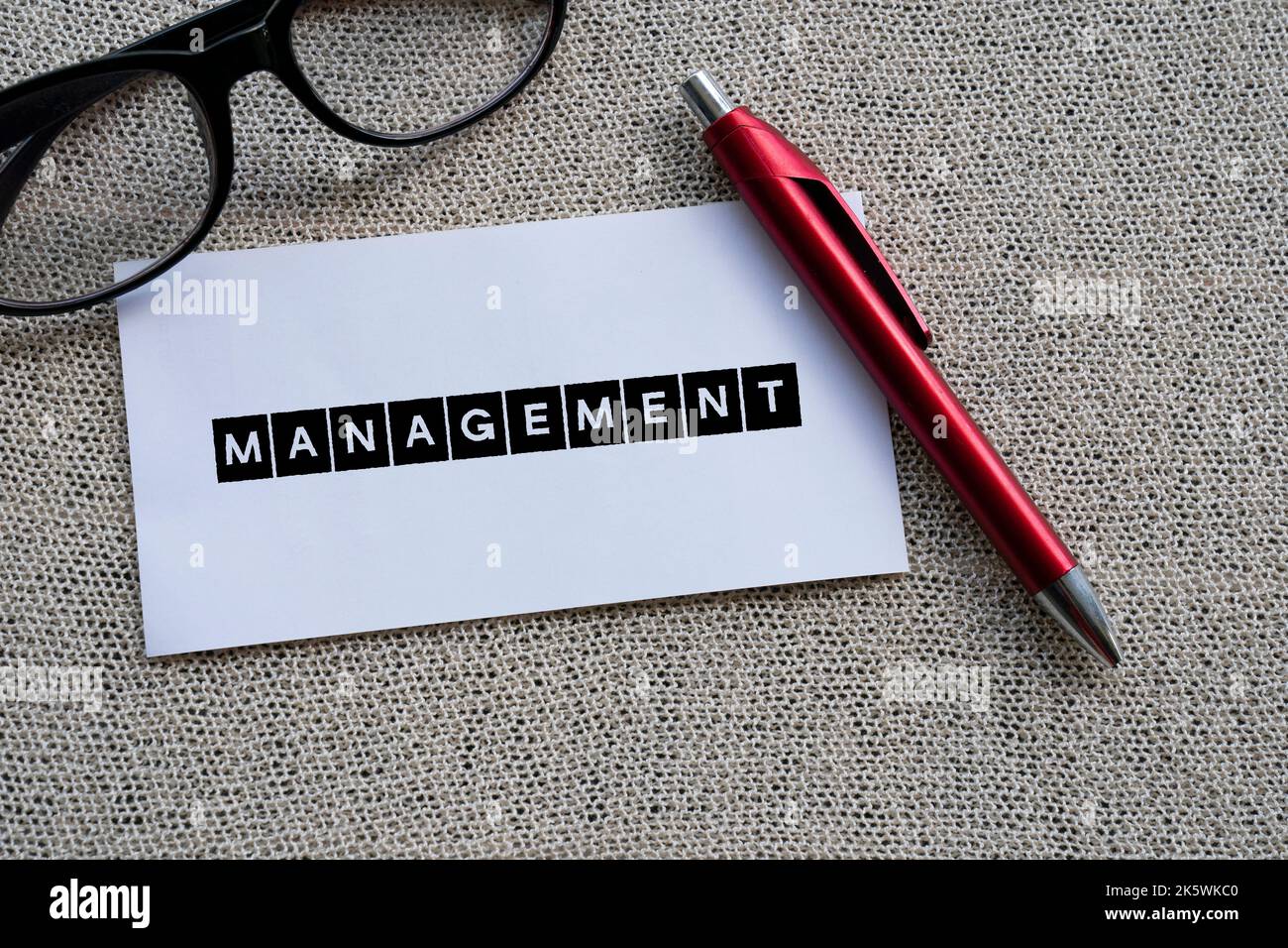 The word MANAGEMENT on white paper with a red pen Stock Photo