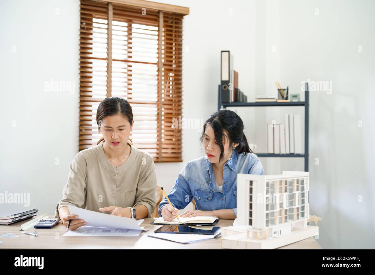 Engineering construction concept, Two female engineers is discussing construction and taking notes. Stock Photo