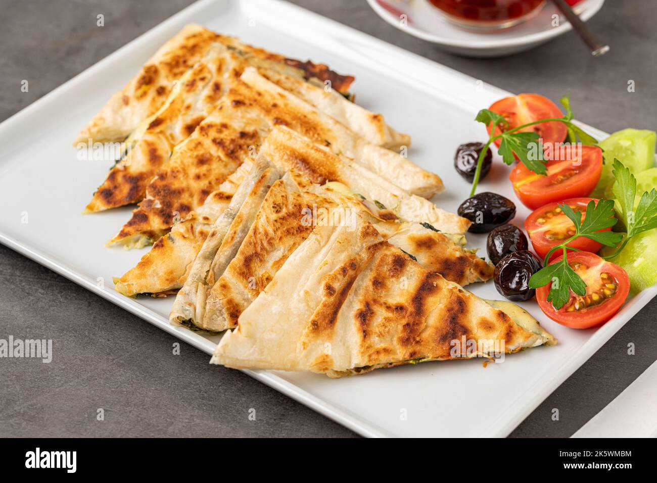 Traditional Turkish flatbread or Gozleme with tomatoes, olives and tea