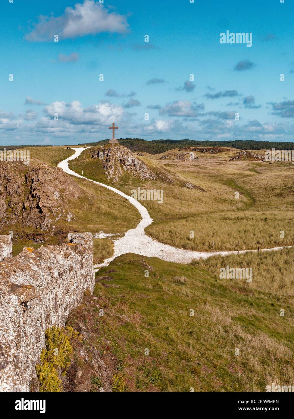 St Dwynwen's Cross, Distant View,  Llanddwyn Island, Anglesey, North Wales, United Kingdom Stock Photo