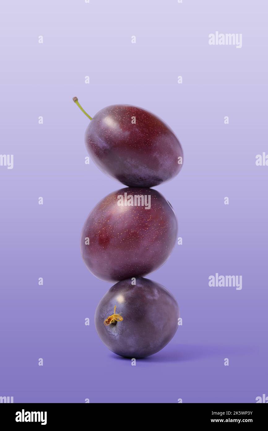 Ripe balancing plum on purple background. Equilibrium food balance Stock Photo - Alamy