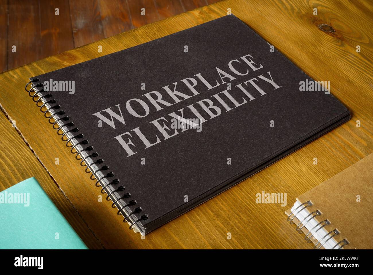Workplace flexibility inscription in the open dark notepad. Stock Photo
