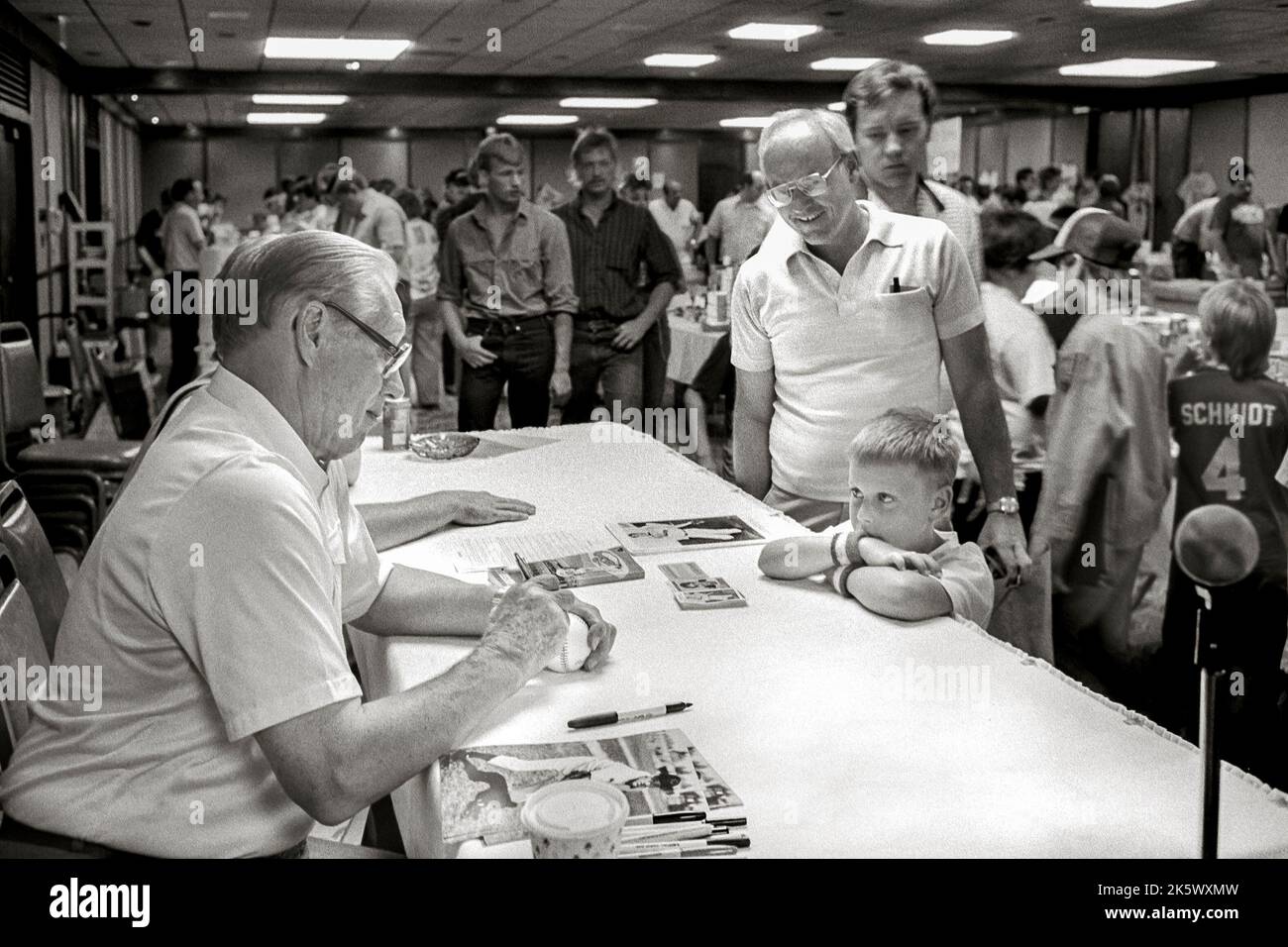 A boy in awe watching Baseball Hall of Fame pitcher Bob Feller signing