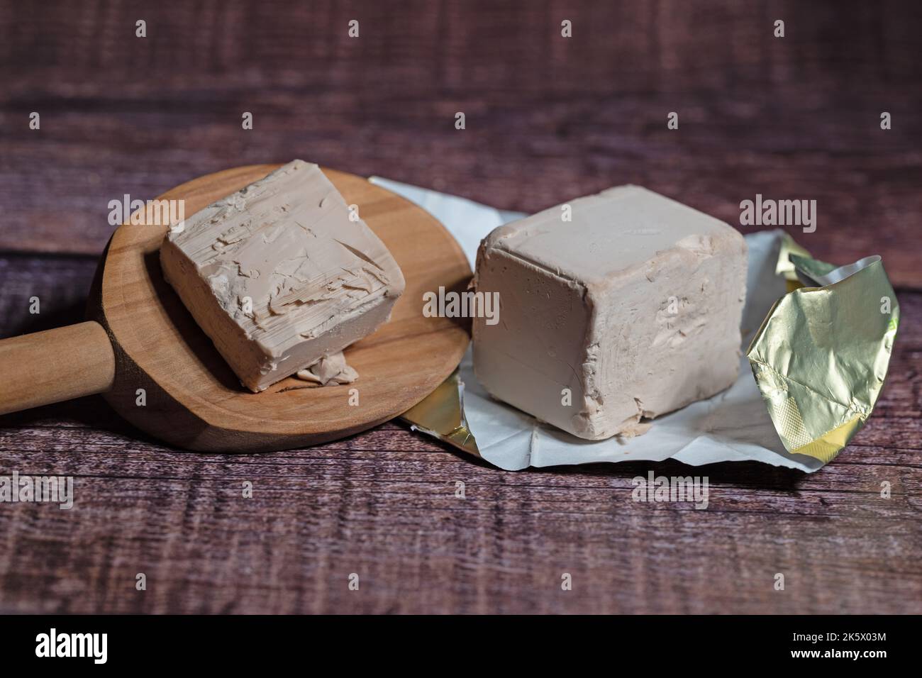 Baker's yeast on a wooden spoon in a closeup Stock Photo