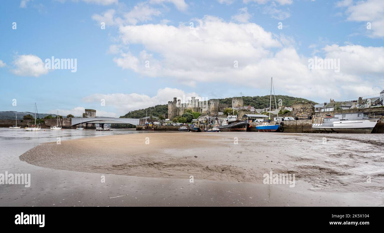 Panoramic view of Conwy Castle and grounded fishing boats from the river bed at low tide in Conwy, Gwnydd, North Wales on 5 October 2022 Stock Photo
