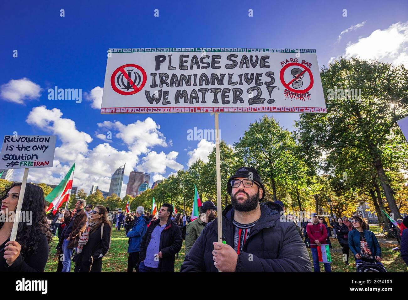 A protester holds a placard that reads 'PLEASE SAVE IRANIAN LIVES WE MATTER  2!' during the demonstration on the Malieveld, The Hague. Iranians and  their supporters gathered hundreds strong in The Hague,