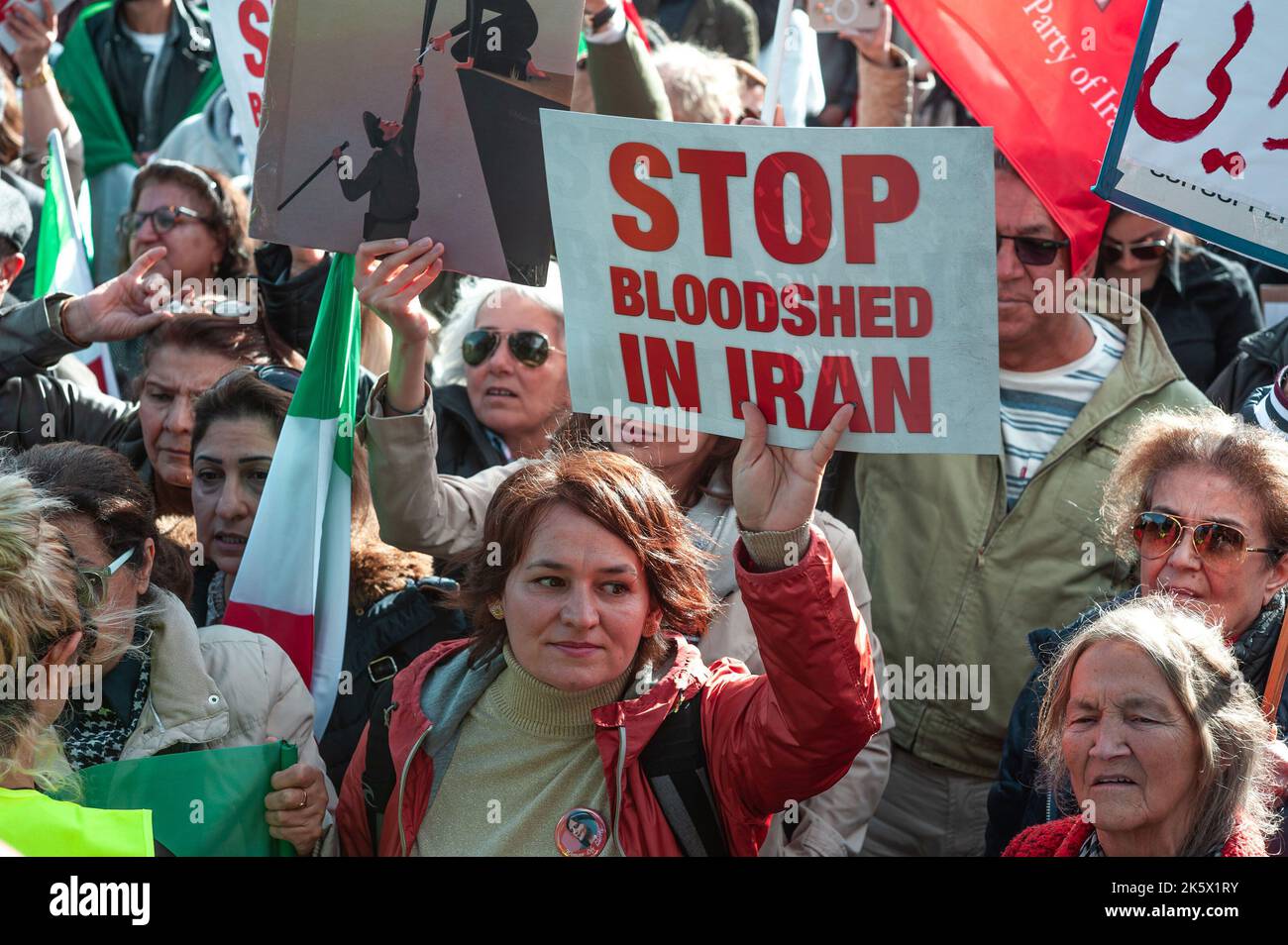 A protester holds a placard that reads ‘STOP BLOODSHED IN IRAN' during