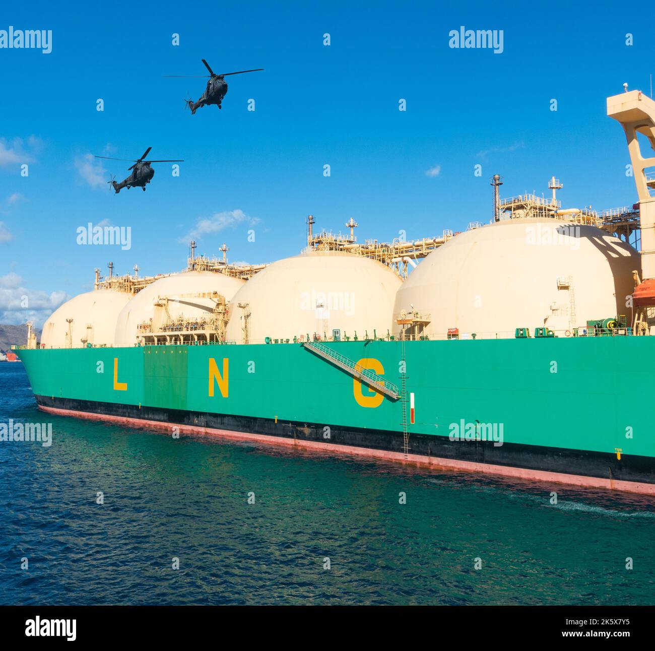 Military helicopters flying over, escorting ship carrying Liquified Natural Gas, Red Sea, Composite image. Gas, energy prices, Russia Ukraine war. Stock Photo