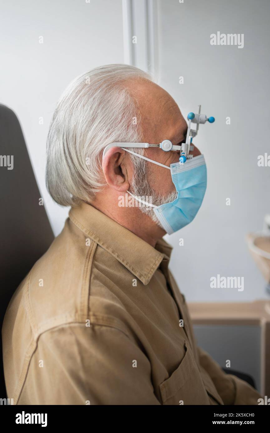 Elderly man sitting wearing medical equipment Stock Photo