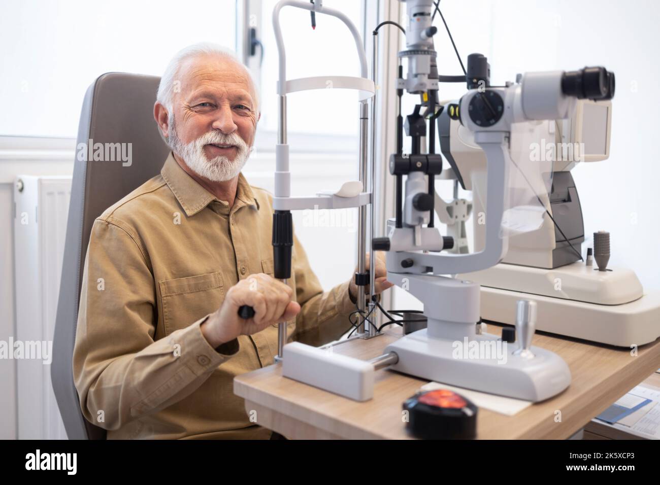 Older man smiling holding clinical equipment Stock Photo