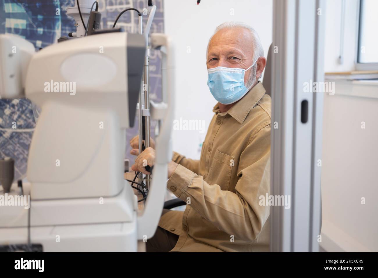 Older man wearing mask holding clinical equipment Stock Photo