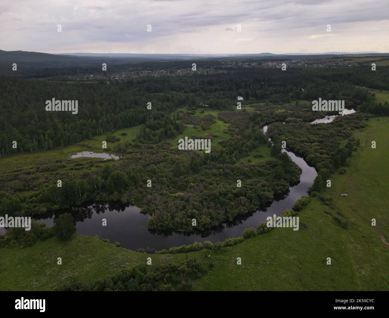 An aerial view of a green field with trees and river Stock Photo - Alamy