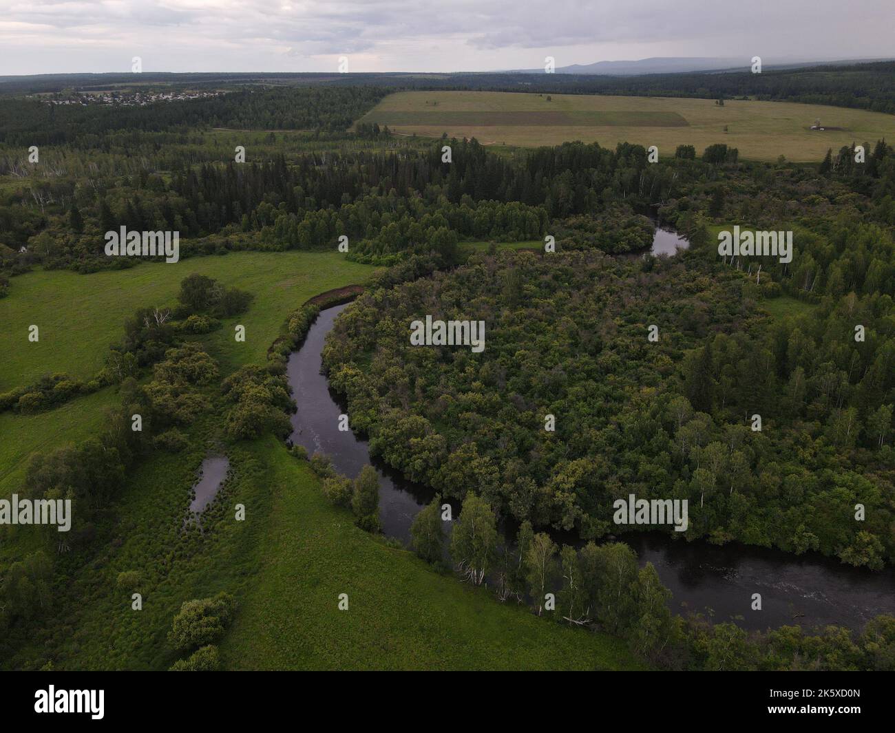 An aerial view of a green field with trees and river Stock Photo - Alamy