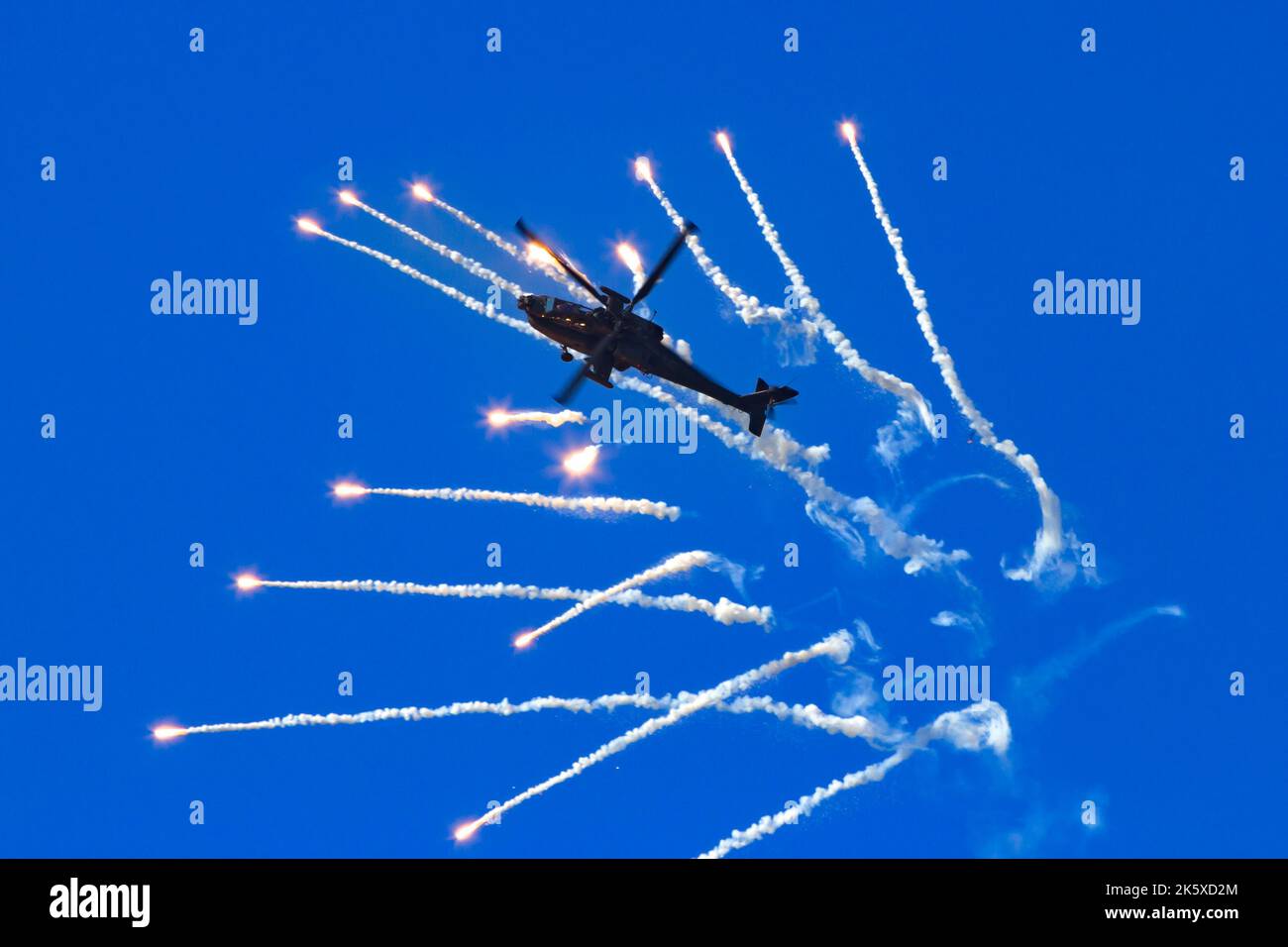 Boeing AH-64 Apache attack helicopter firing flares during a flight demonstration at Kleine Brogel, Belgium - September 13, 2014 Stock Photo