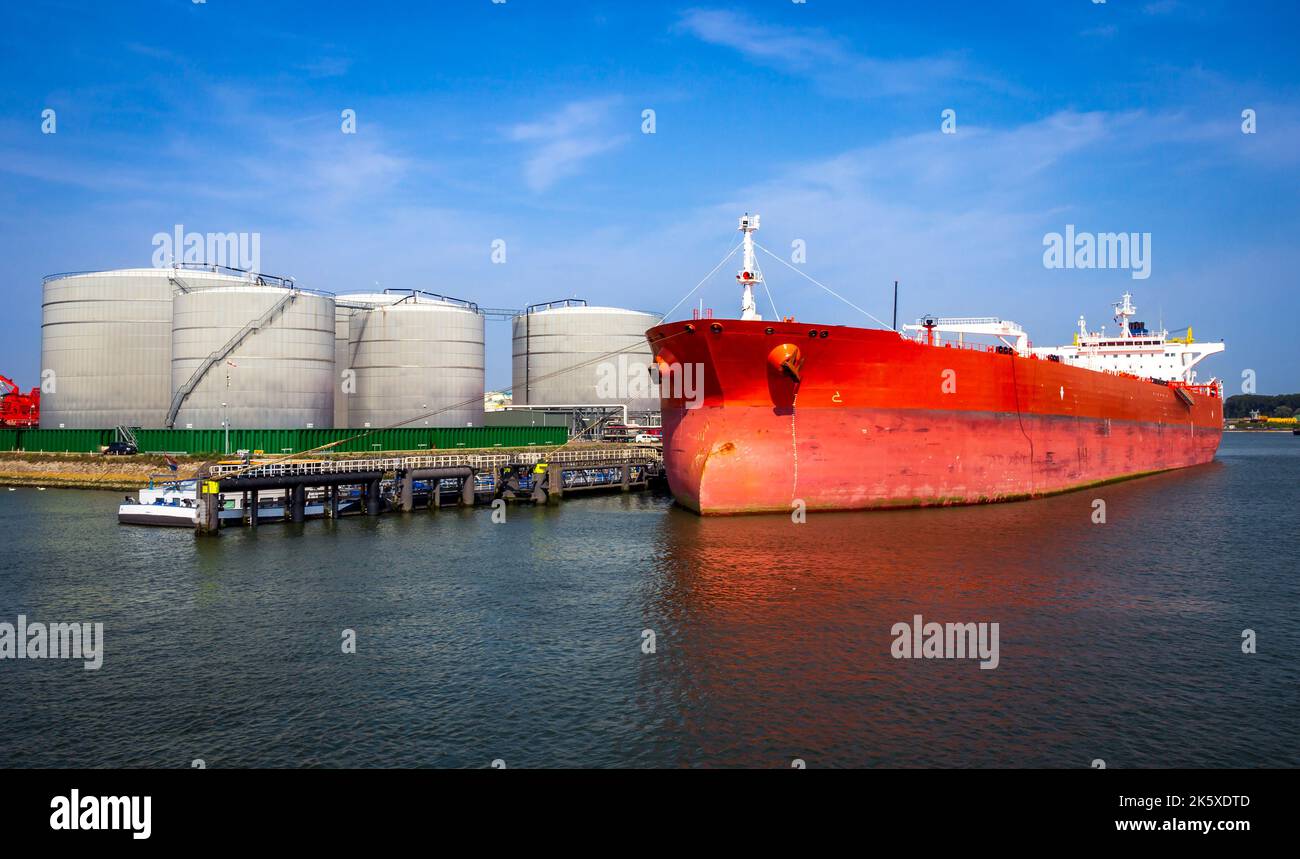 Crude oil tanker docked at a oil storage silo terminal in the port. Stock Photo