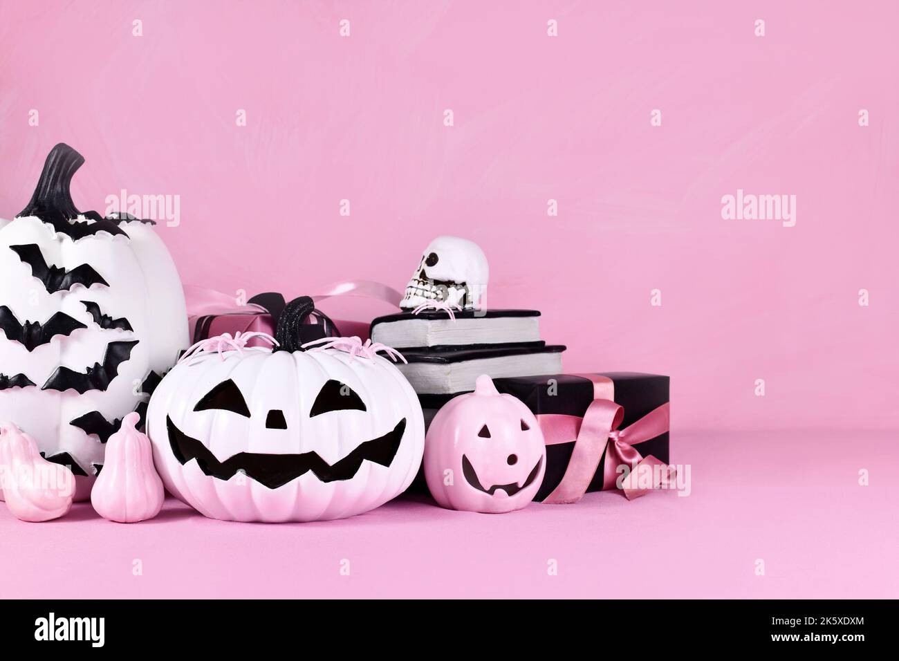 Pink Halloween decor with pink and black and white pumpkins and copy