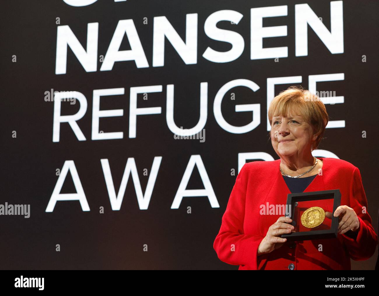 Angela Merkel poses with the UNHCR Nansen Refugee Award for protecting refugees at height of Syria crisis, during a ceremony in Geneva, Switzerland, October 10, 2022. REUTERS/Stefan Wermuth/Pool Stock Photo