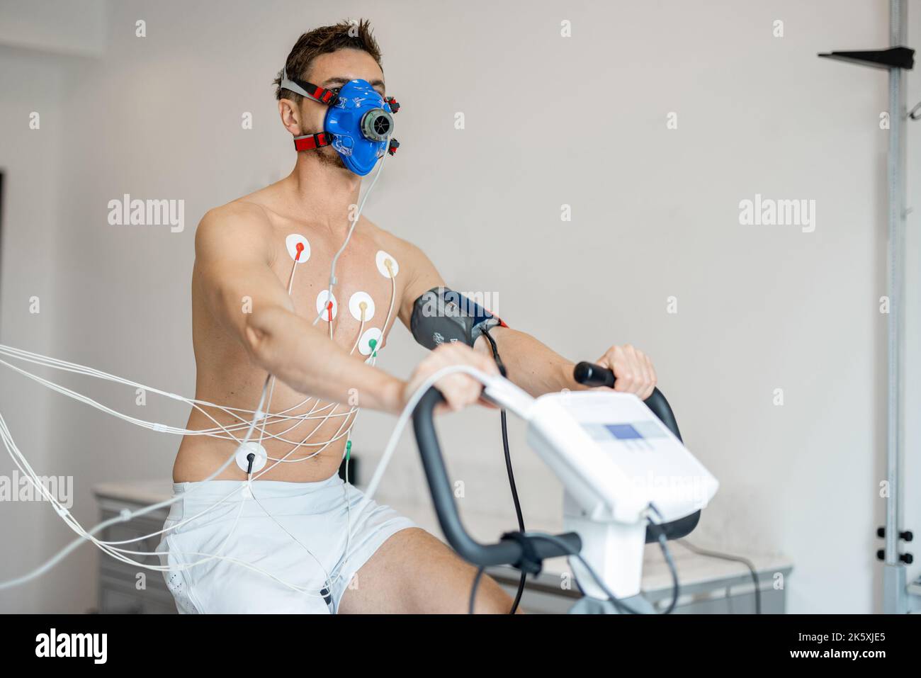 Man examining his cardiovascular system on bike simulator Stock Photo