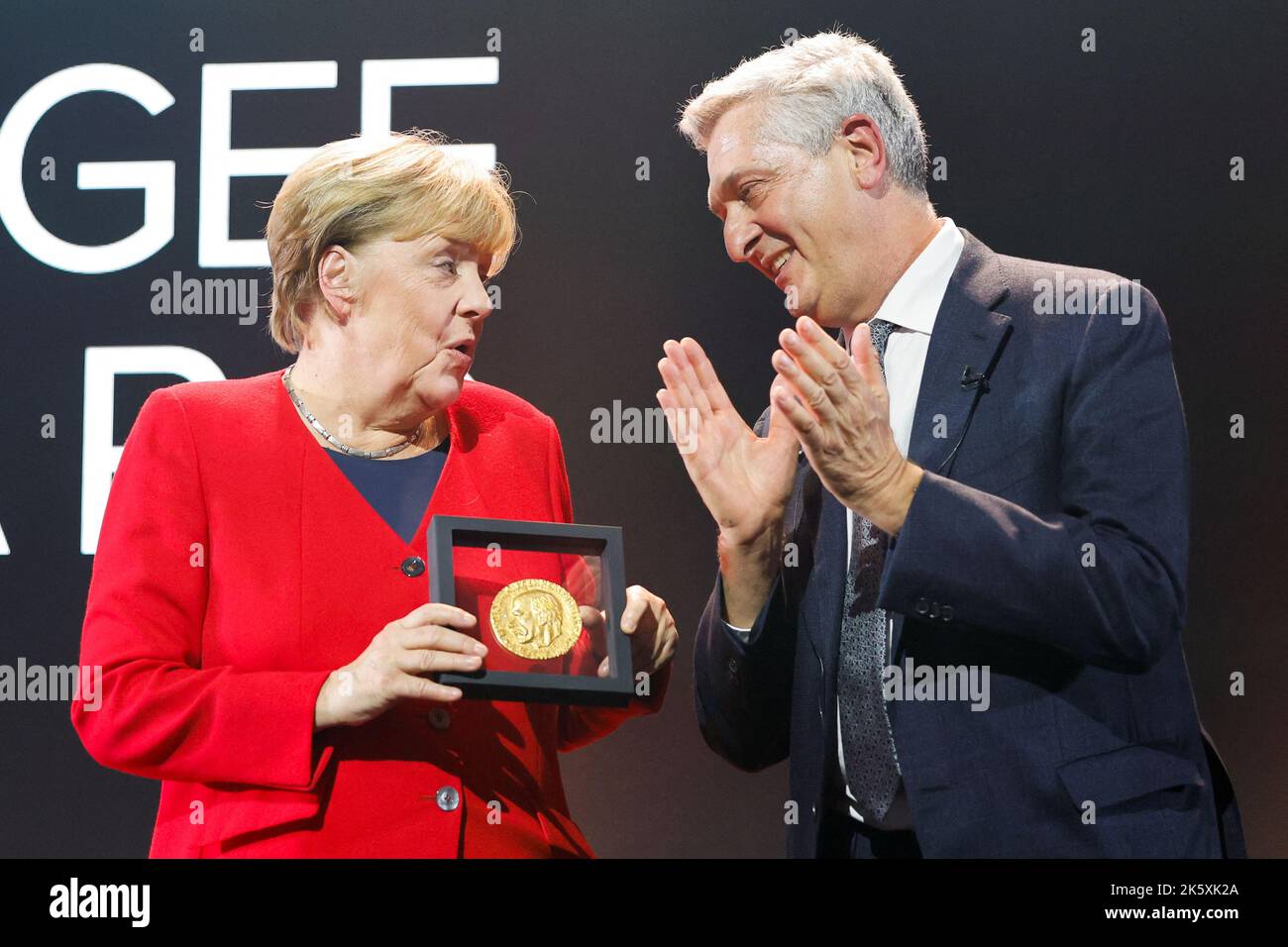 Angela Merkel receives the UNHCR Nansen Refugee Award for protecting refugees at height of Syria crisis, from United Nations High Commissioner for Refugees Filippo Grandi, during a ceremony in Geneva, Switzerland, October 10, 2022. REUTERS/Stefan Wermuth/Pool Stock Photo