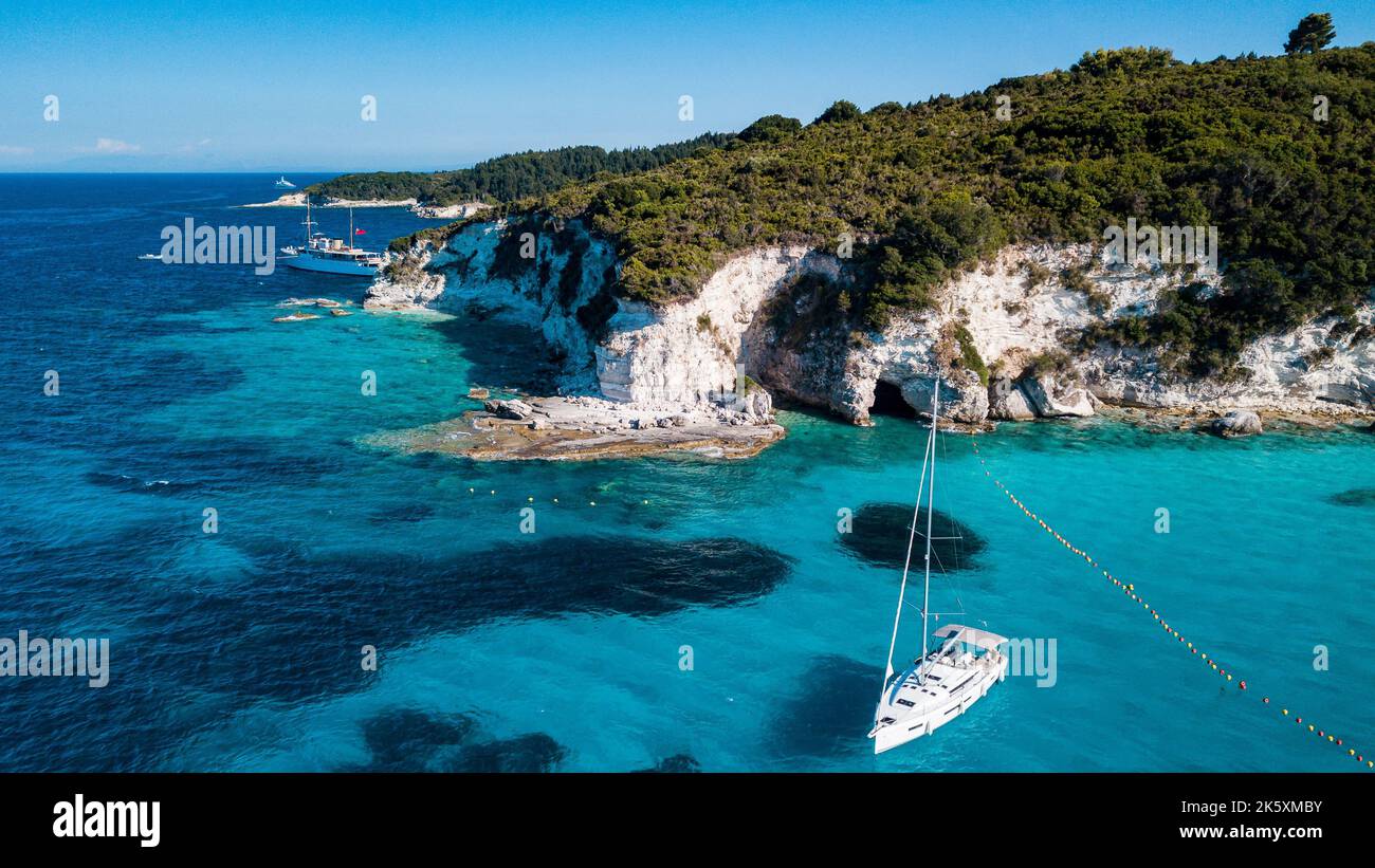 An aerial view of white yacht in the blue sea by lush green island ...