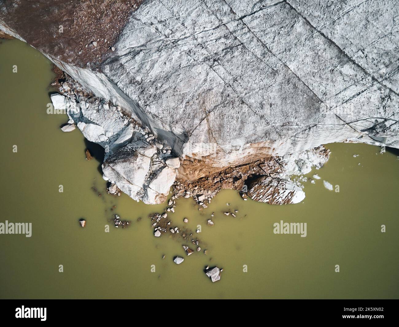 Beautiful scenery of the ice glacier with crack and mountain lake near Almaty city, Kazakhstan. Aerial shot with drone top down view outdoor Stock Photo