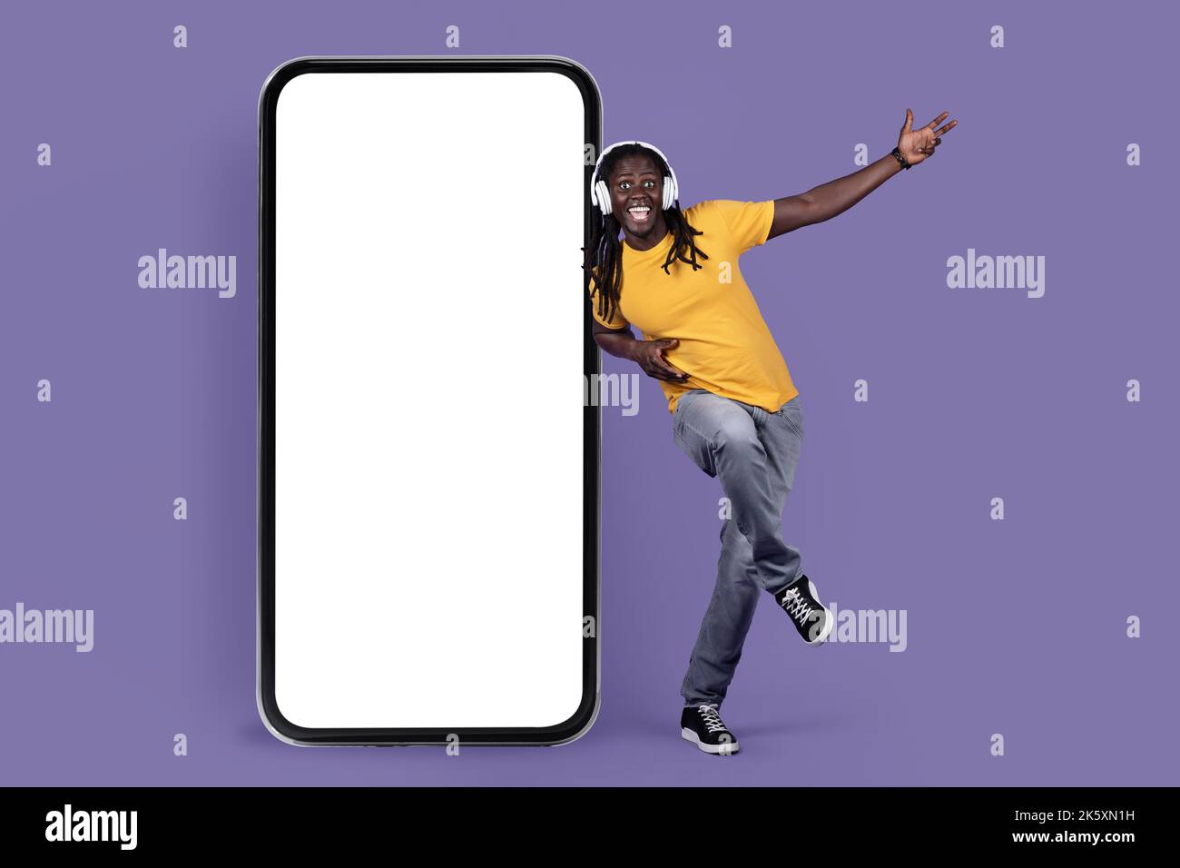 Happy black guy listening to muisc, using wireless headset Stock Photo