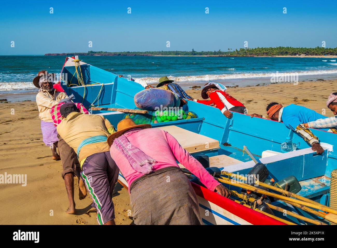 Fishermen on the Konkan Coast of India hauling fishing nets from the sea Stock Photo