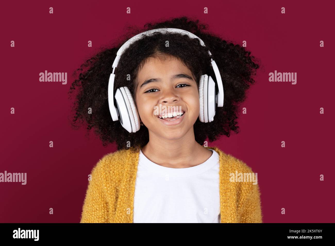 Closeup portrait of cheerful black kid using wireless headphones Stock Photo