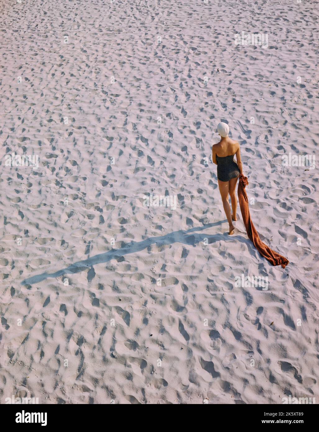 Rear View Portrait of Woman in One-Piece Swimsuit walking on Beach, Toni Frissell Collection, December 1948 Stock Photo