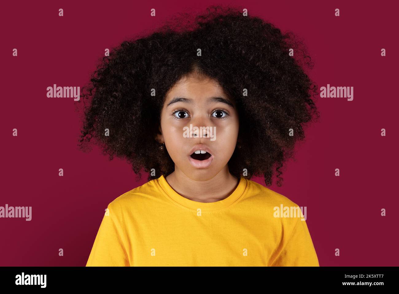 Portrait of shocked black girl on colorful background Stock Photo