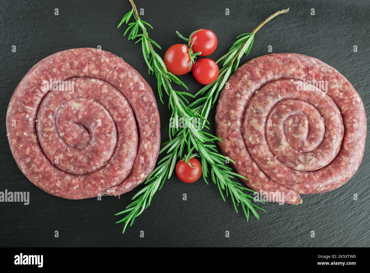 Spiral pork sausage on black board Stock Photo