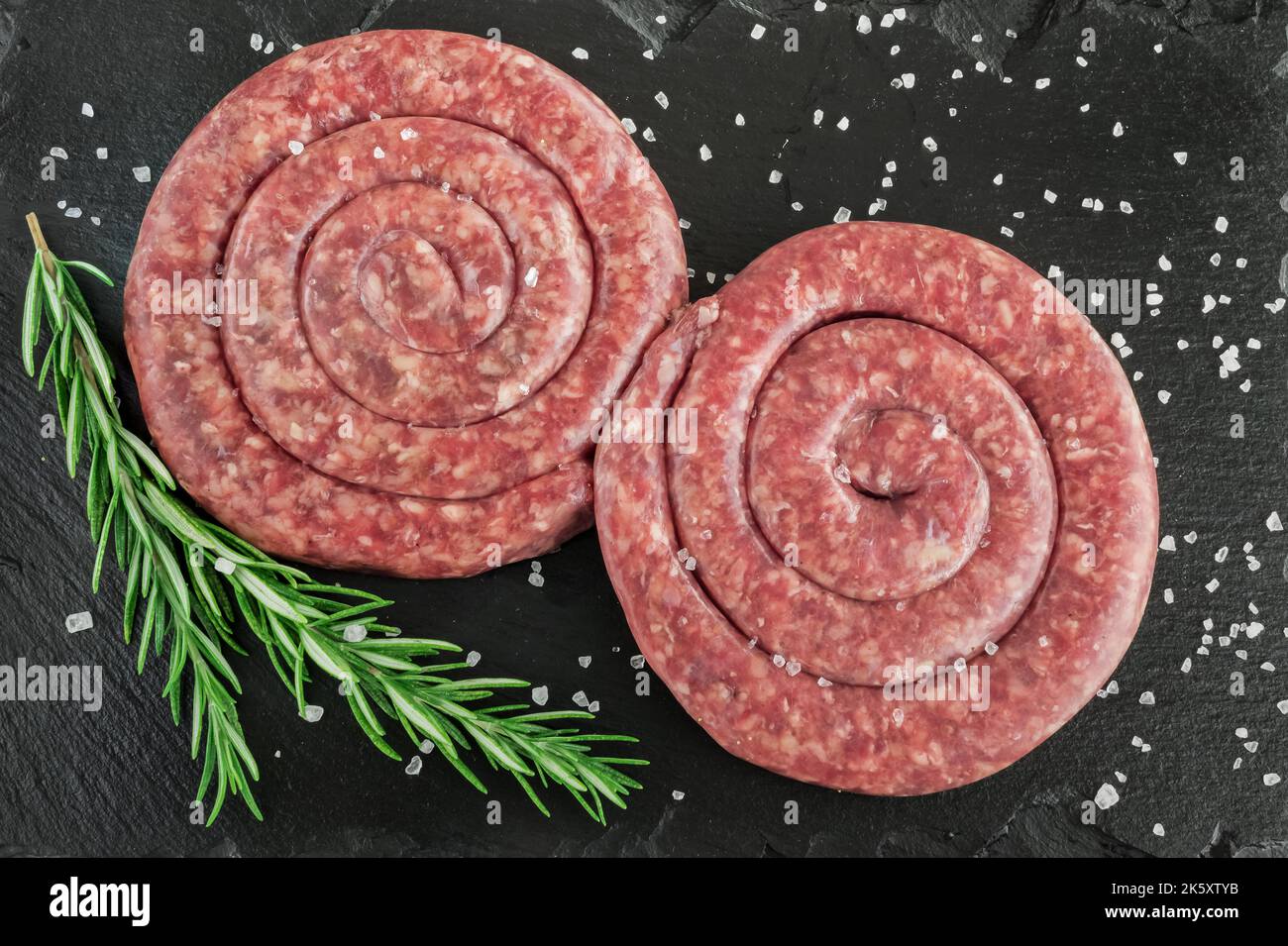 Spiral pork sausage on black board Stock Photo