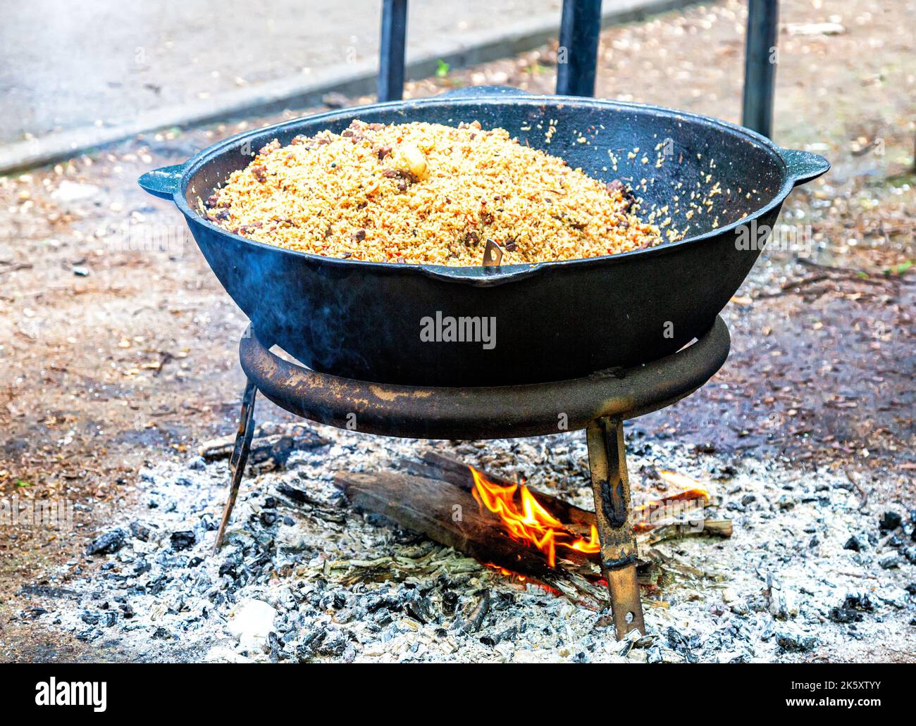 https://c8.alamy.com/comp/2K5XTYY/cooking-appetizing-traditional-uzbek-pilaf-in-a-large-cauldron-on-the-open-fire-outdoors-2K5XTYY.jpg