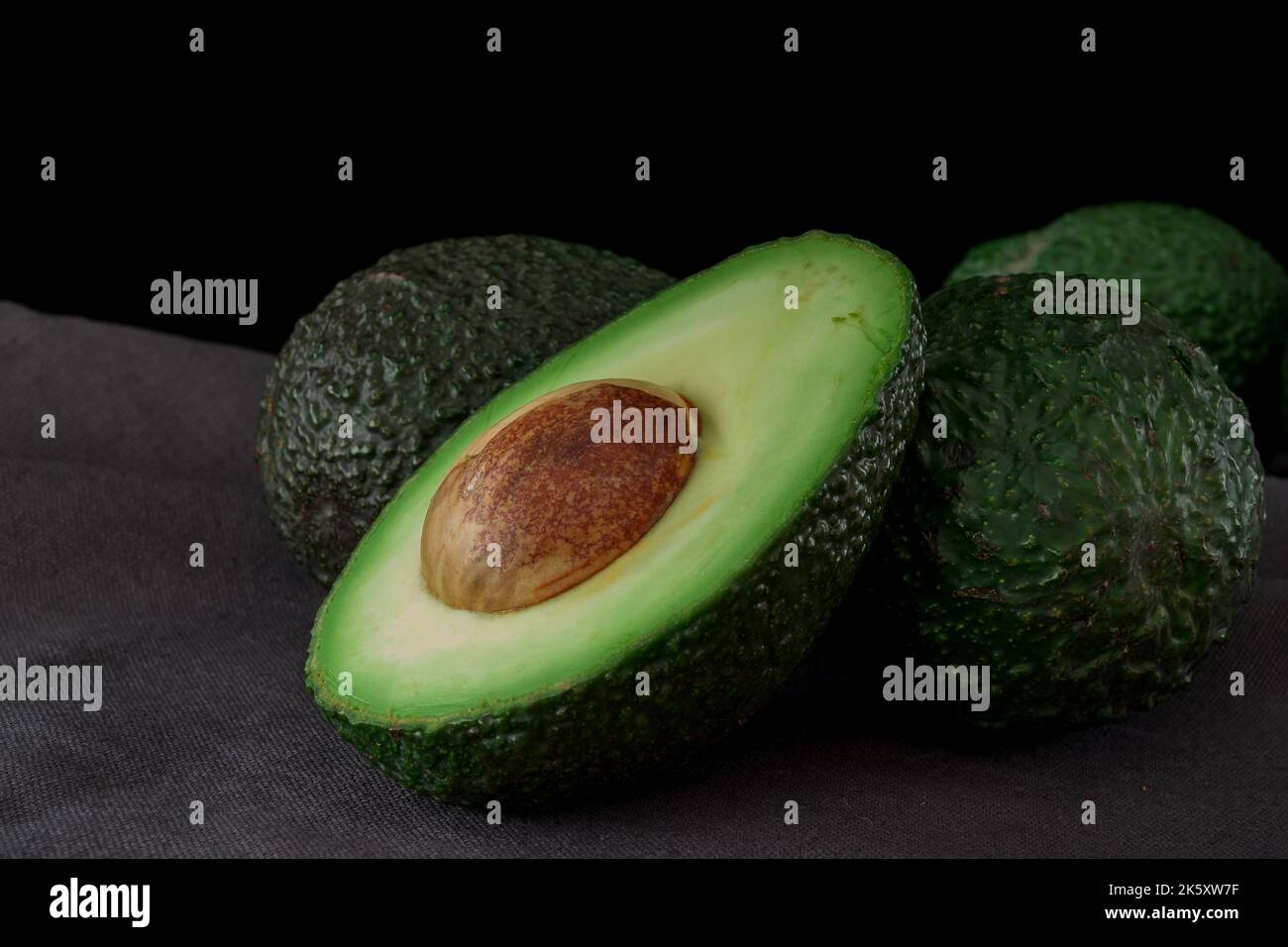Persea americana fruit cut into two with seed, Avocado Stock Photo