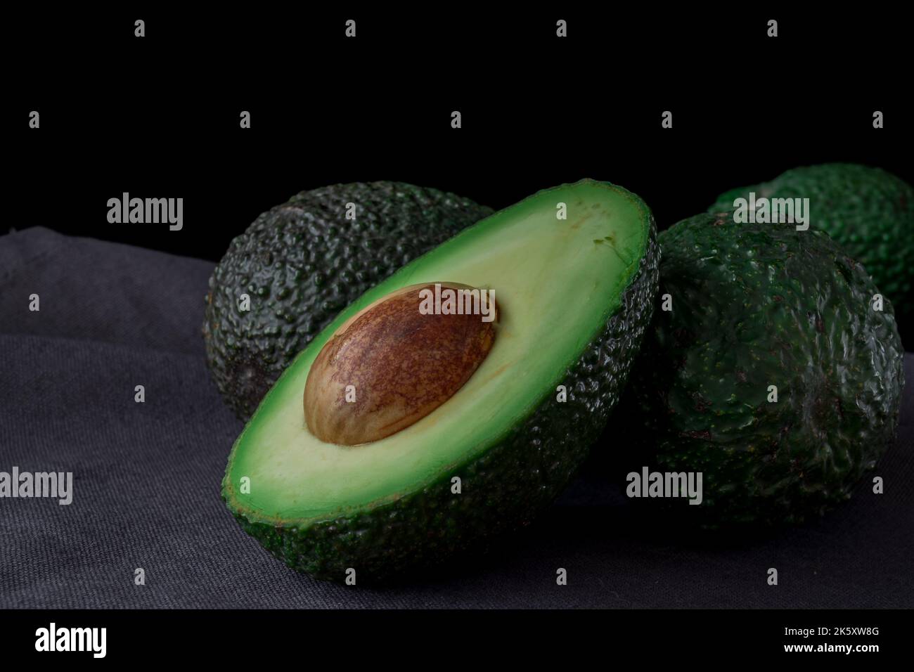 Persea americana fruit cut into two with seed, Avocado Stock Photo