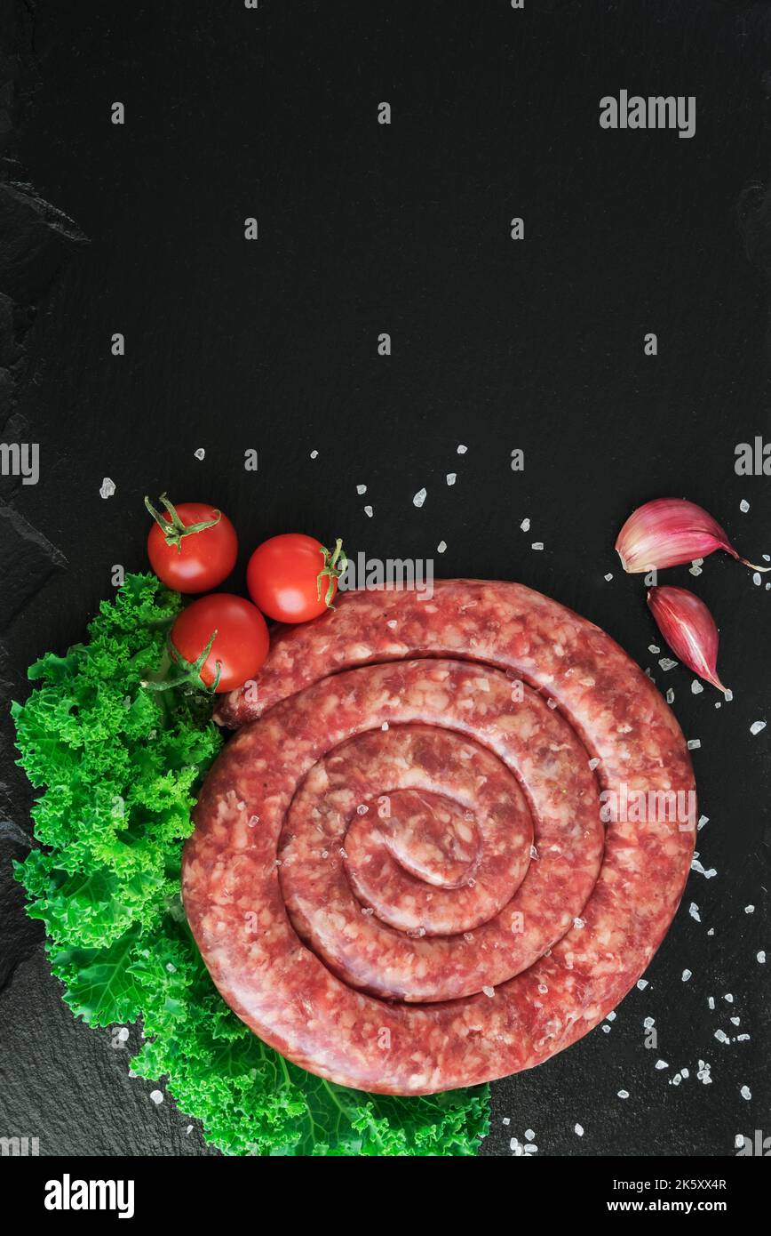 Spiral pork sausage on black board Stock Photo