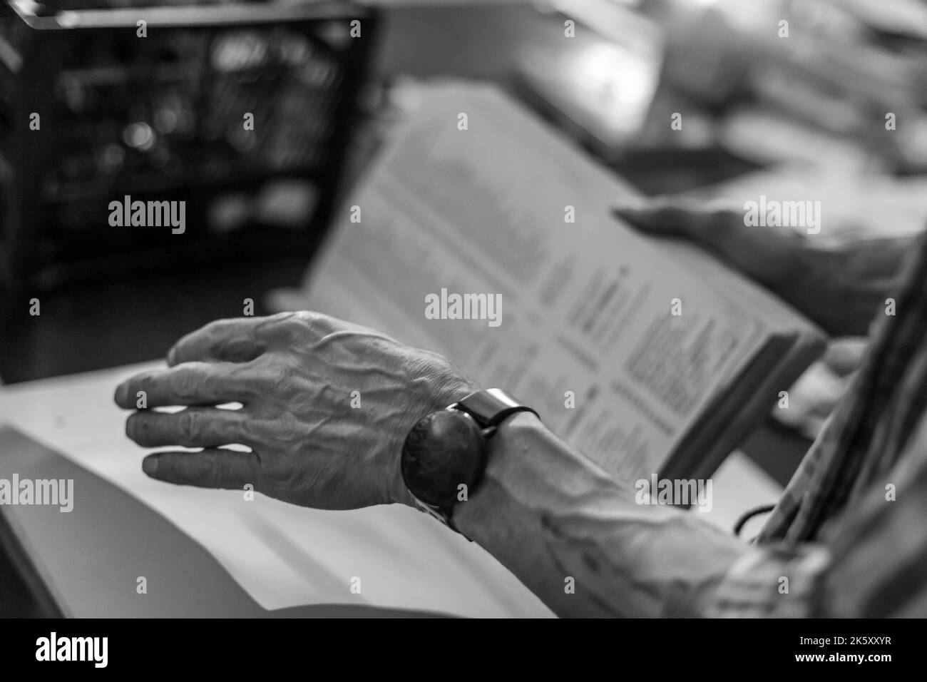 A grayscale closeup of a senior's hand with blurred background Stock Photo