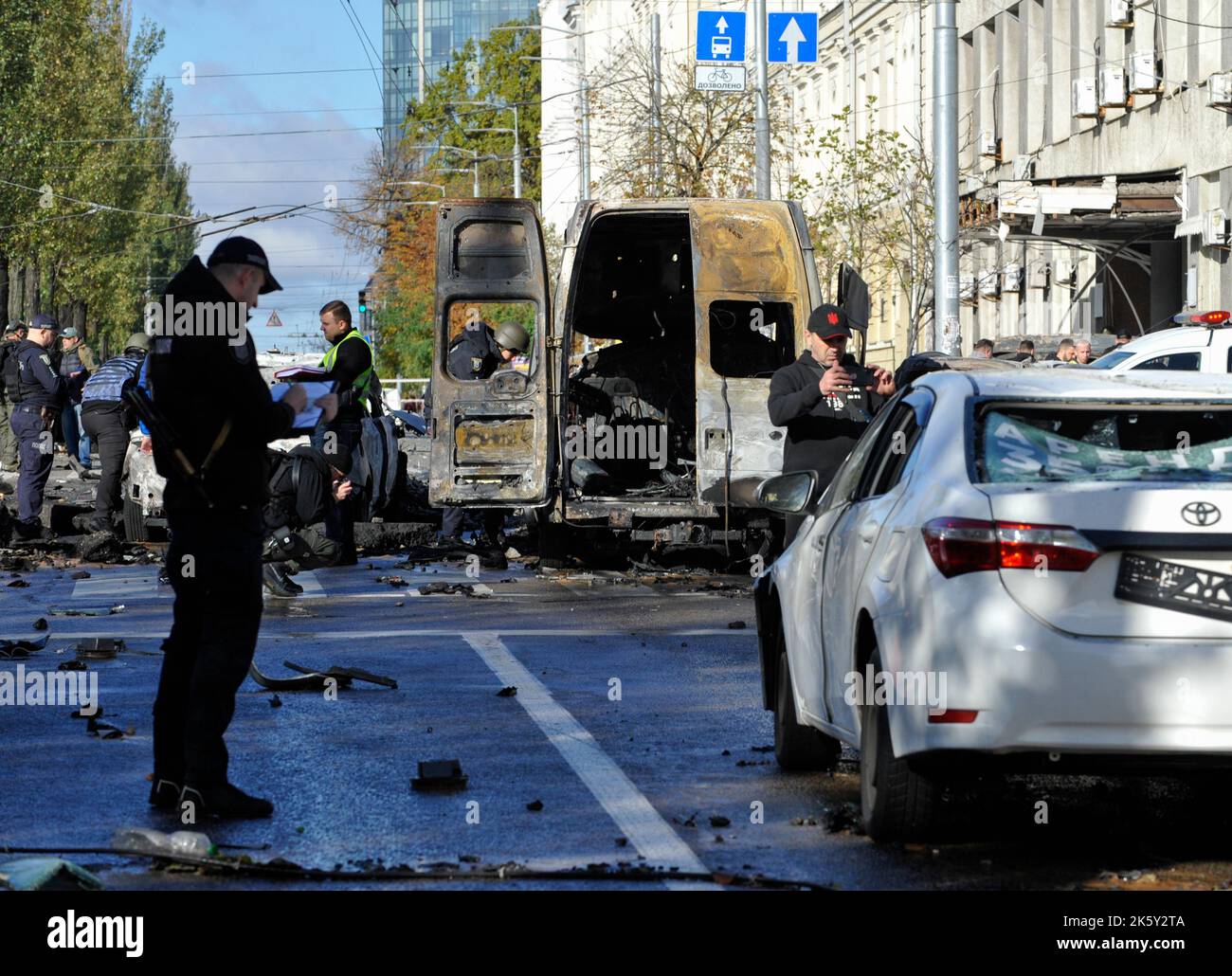 Kyiv, Ukraine. 10th Oct, 2022. The police conducts investigative actions near the burned-out cars that were damaged as a result of rocket fire by the Russian army in the city center. As a result of a massive Russian missile attack on Monday, October 10, critical infrastructure facilities in 12 regions of Ukraine and Kyiv 11 people died, 89 were injured. 117 objects were damaged, including 35 residential buildings. Credit: SOPA Images Limited/Alamy Live News Stock Photo