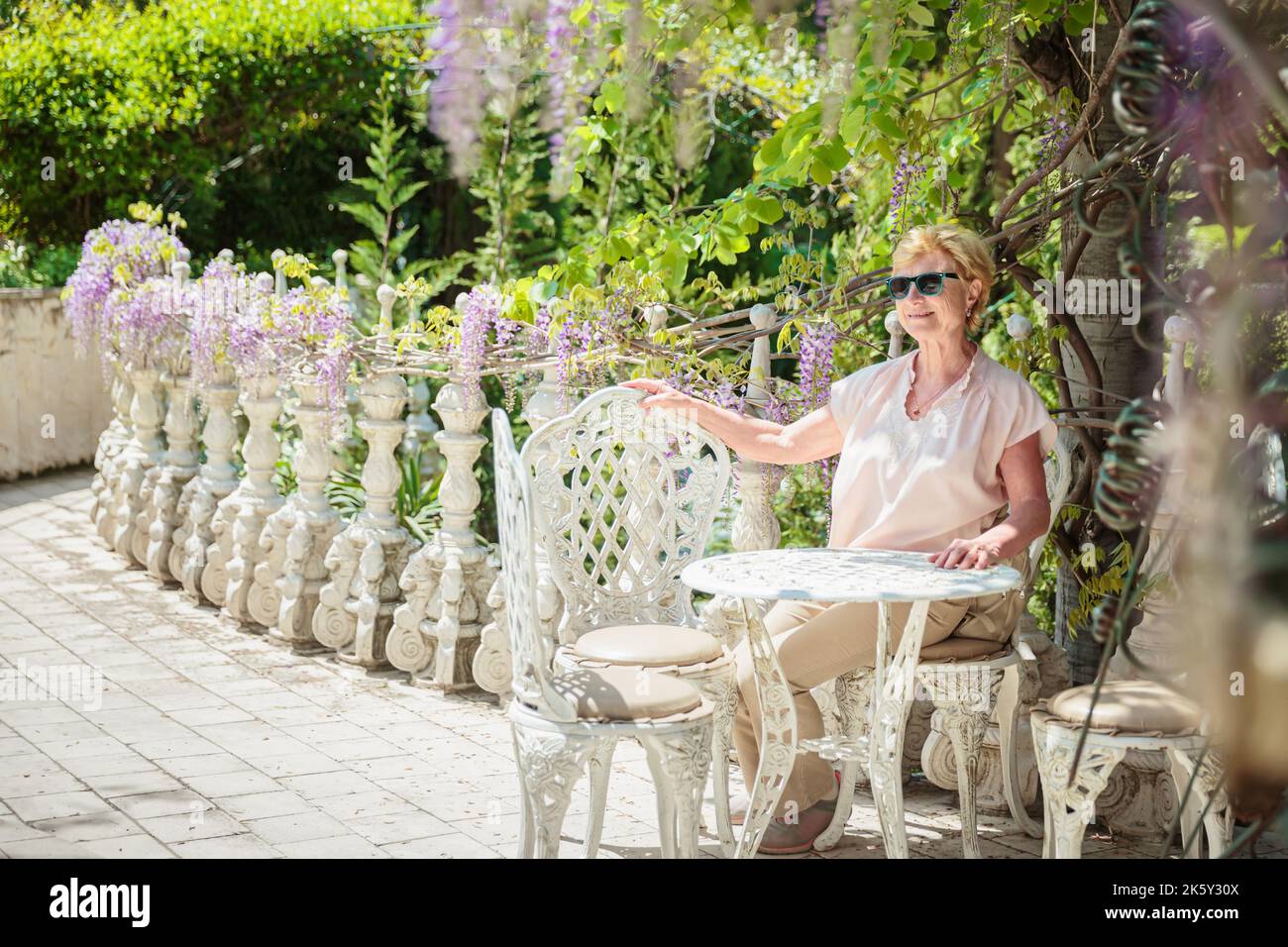 Mature woman traveler sitting alone on the terrace of coffee shop Stock ...
