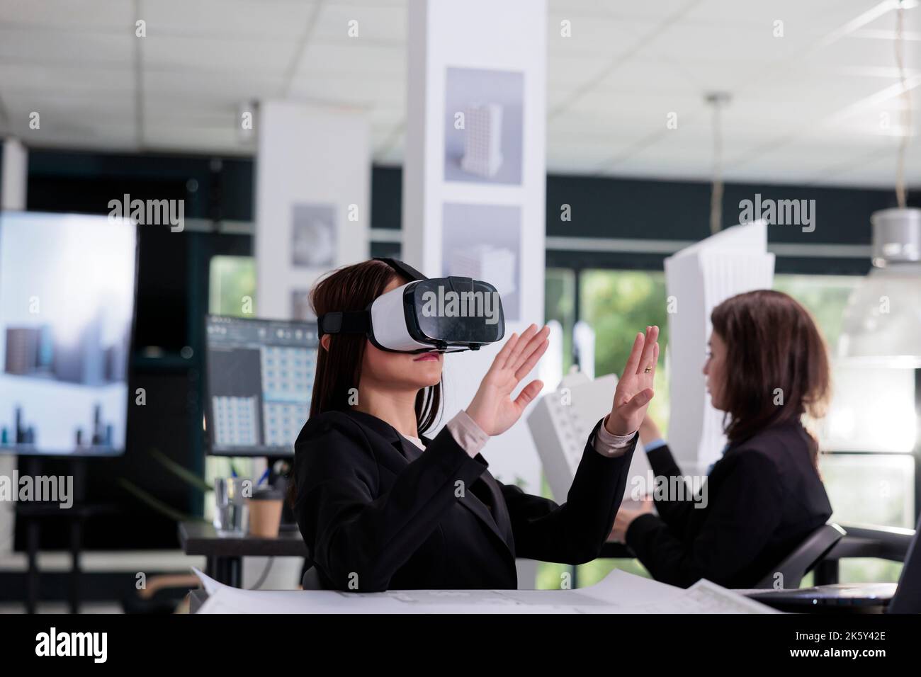 Architect in vr headset working on project in metaverse. Asian employee