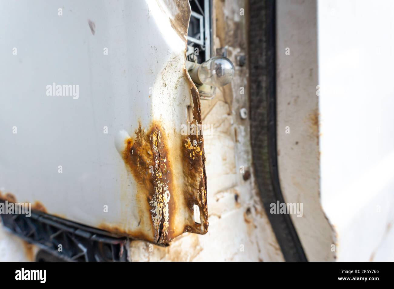 Rusty back of an old white car, minivan and no tail light close-up. Stock Photo