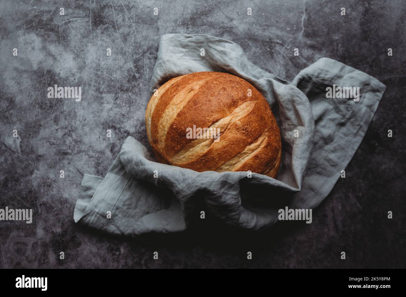 Top view of a loaf of sourdough bread on a grey background. Stock Photo