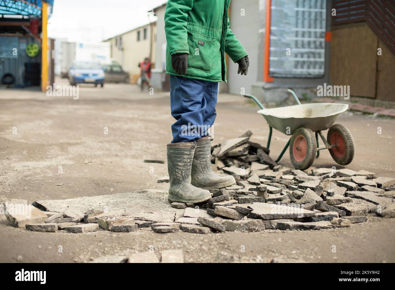Guy makes road. Man at work. worker stands on broken asphalt. Stock Photo