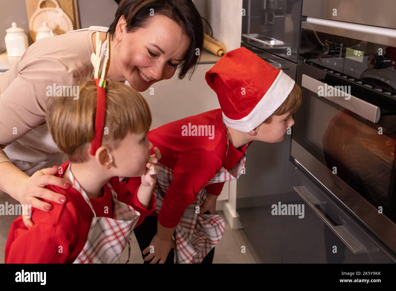 Family waiting for gingerbread cookies to cook in the oven Stock Photo