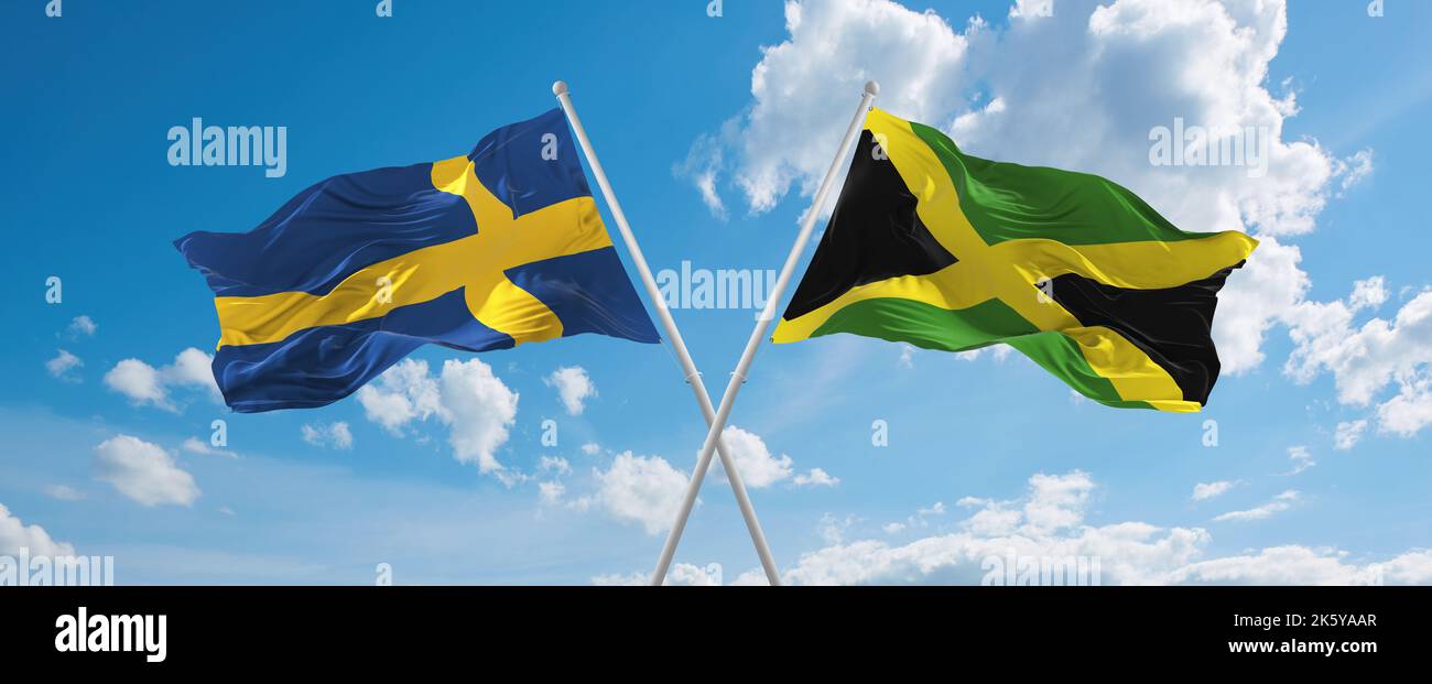 two crossed flags Jamaica and Sweden waving in wind at cloudy sky ...